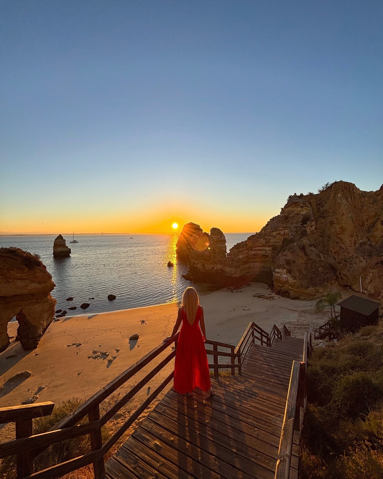 Wooden steps down to an Algarve beach at sunrise